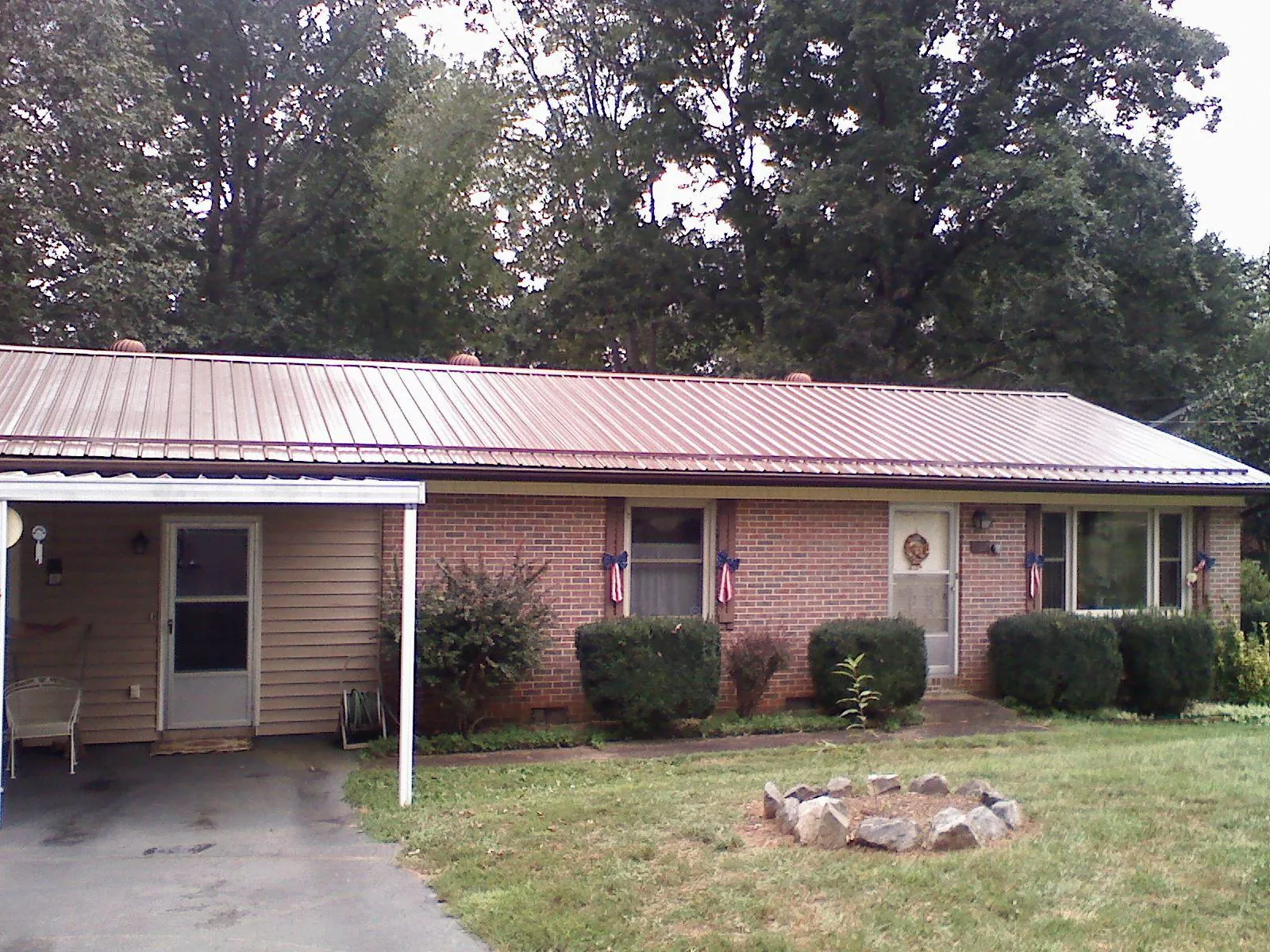 Bronze metal roof and carport on a brick ranch home — Roof Repair work by our crew in Altoona