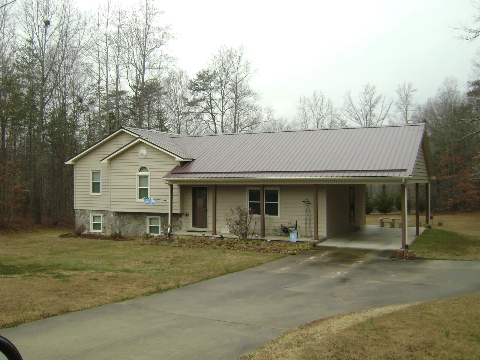 Brown metal roof on a tan split level home with an attached carport in Altoona